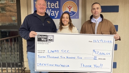 Dave Painter, Amy Rohler, Kent Joesel pose with a check outside the UWAY SCC office.